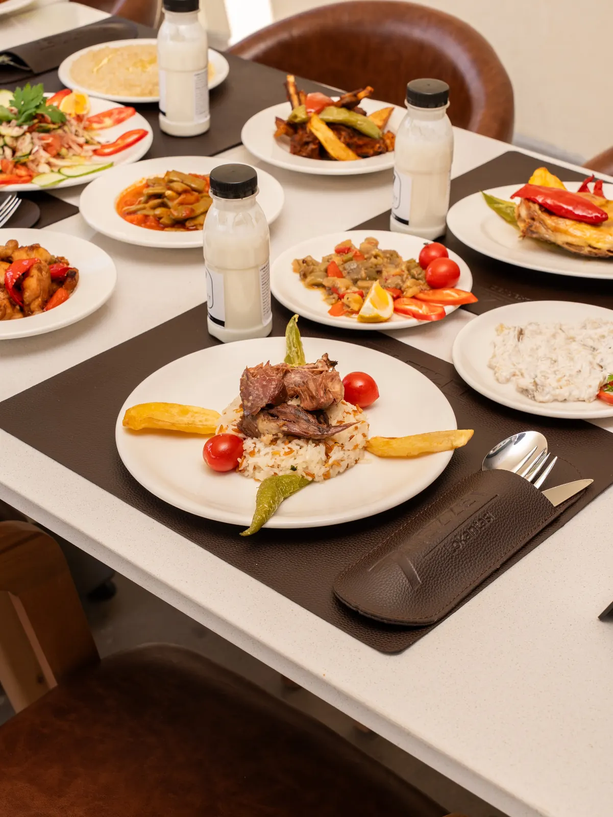 Ayranlar, mezeler ve kuzu tandırla kurulmuş masa.